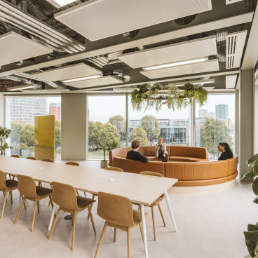 Modern workspace featuring a circular lounge area and a long table, designed for collaboration at Butternut Box.