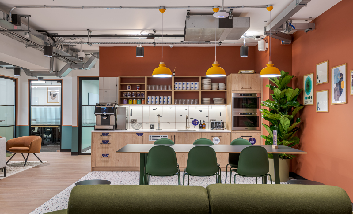 Stylish co-working kitchen area featuring modern furnishings, vibrant colors, and a coffee station in The Typewriter building.