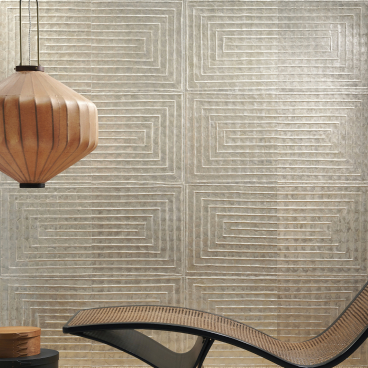 Elegant lounge chair positioned in front of textured wallcovering and warm pendant lamp, showcasing Arte's sophisticated Spring collections.