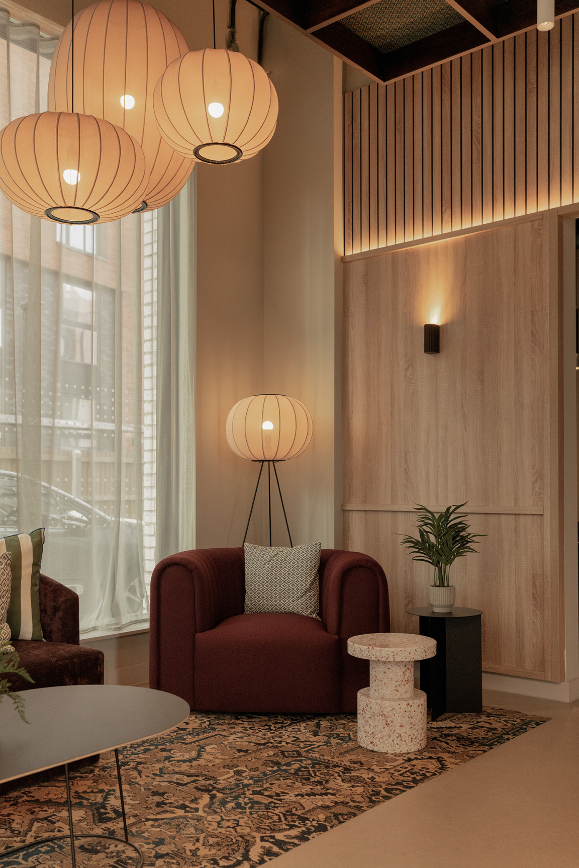 Sophisticated interior design featuring a burgundy chair, decorative cushions, unique lighting, and textured walls at The Place in Nottingham.