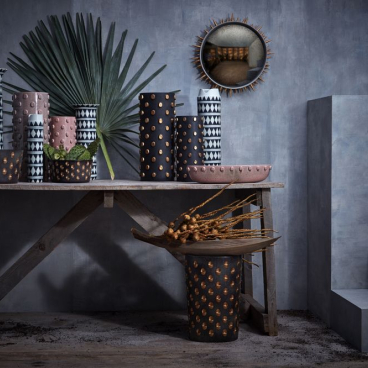 Colorful vases and decorative objects arranged on a wooden table, showcasing contemporary Middle Eastern design aesthetics.