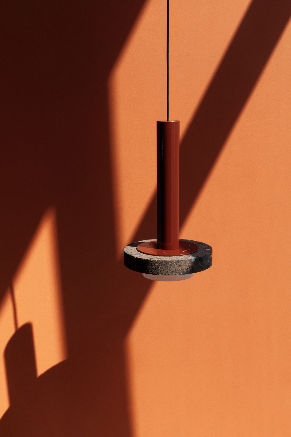 Volcanic stone pendant light design by davidpompa, showcasing modern aesthetics against an orange wall backdrop.