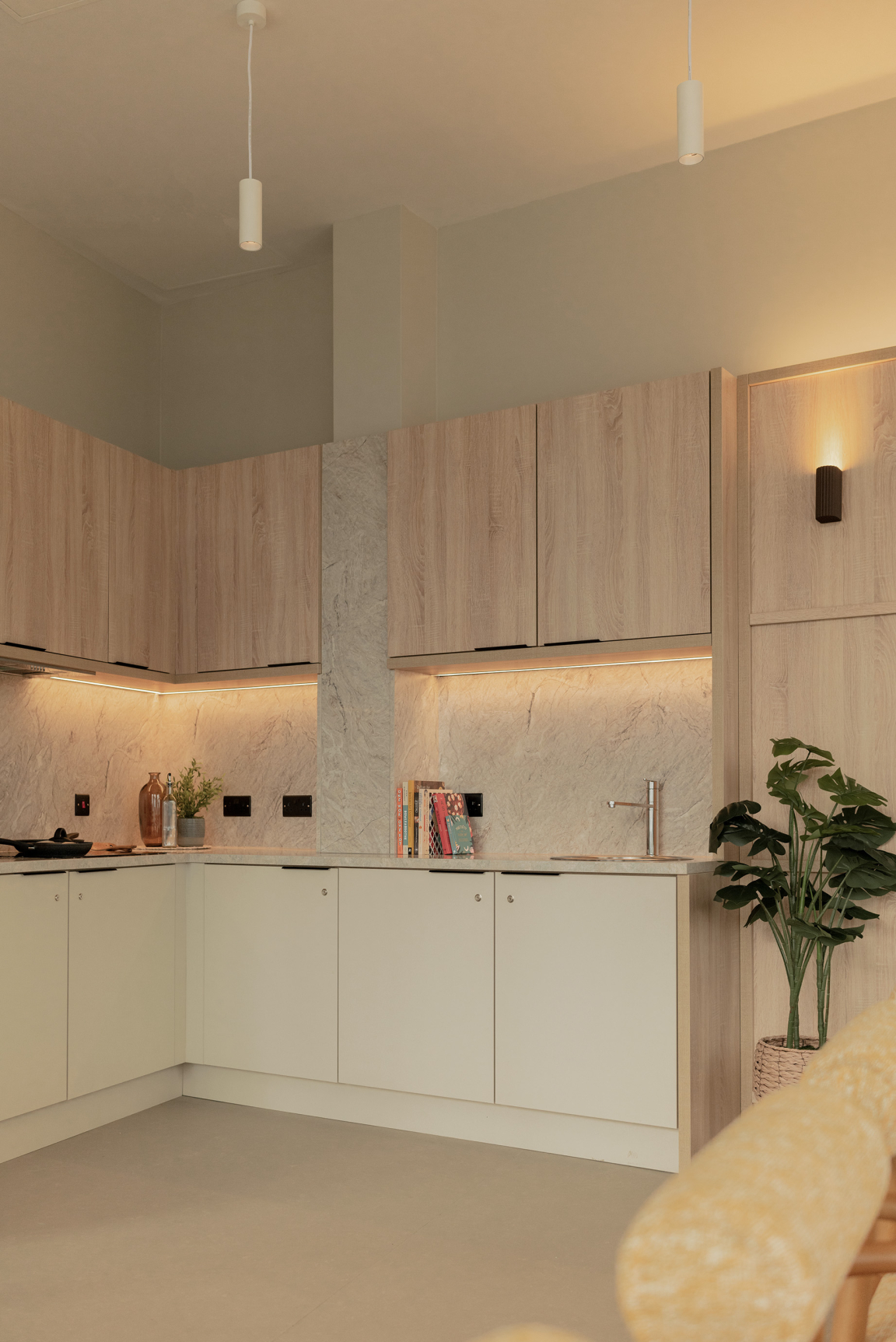 Sophisticated kitchen design featuring textured stone walls, modern cabinetry, and stylish lighting in The Place, Nottingham.