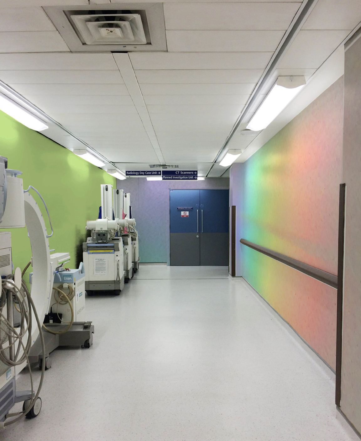 Colorful hospital corridor featuring medical equipment, with bright walls highlighting a modern healthcare environment.