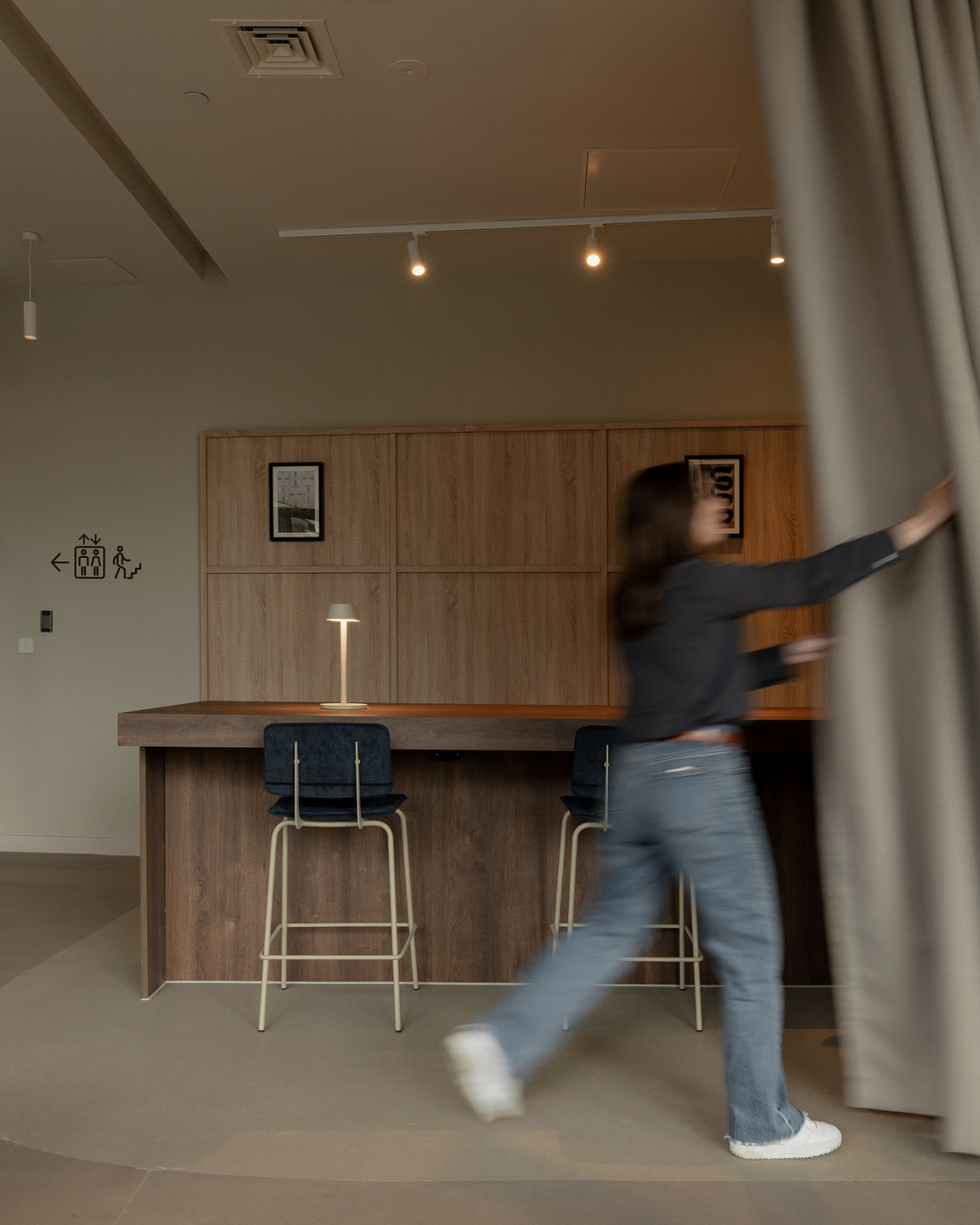 Sophisticated interior of The Place in Nottingham, featuring a bar area and a person pulling back curtains.