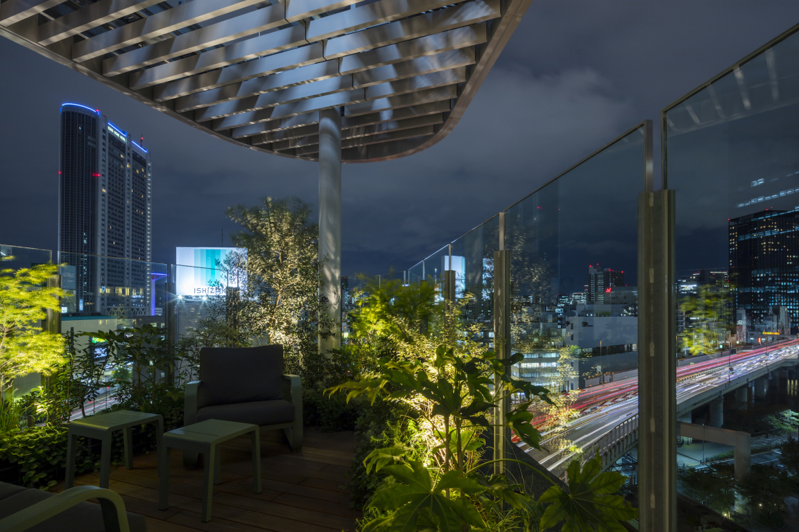 Rooftop garden terrace view at night, showcasing Tokyo's skyline and modern architecture, perfect for urban relaxation.