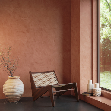 Stylish interior featuring Cosentino's Dekton® surface, showcasing a modern chair, elegant vases, and a warm color palette.