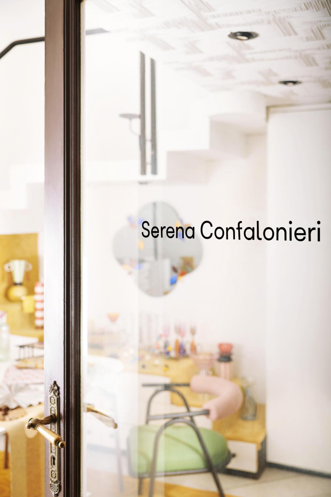 Welcoming entrance featuring the name "Serena Confalonieri" with a glimpse of a vibrant, stylish interior space.