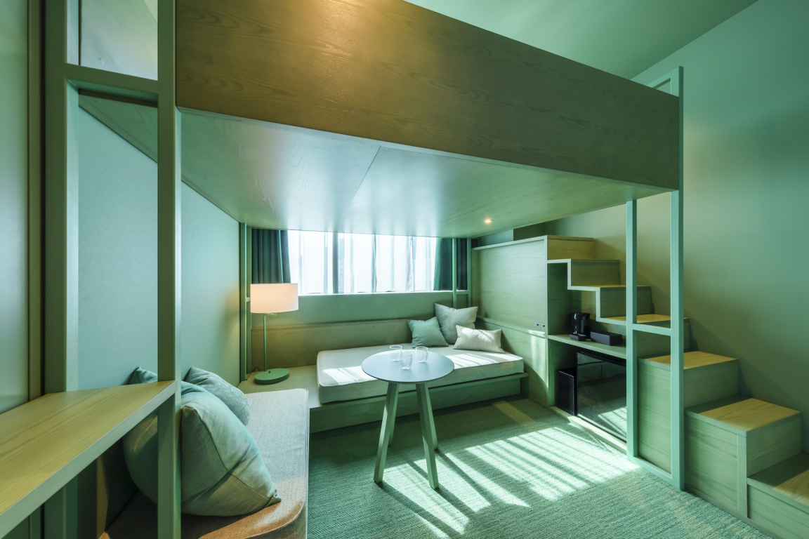 Stylish hotel room in Toggle Hotel Tokyo featuring modern design elements, a cozy seating area, and large windows.