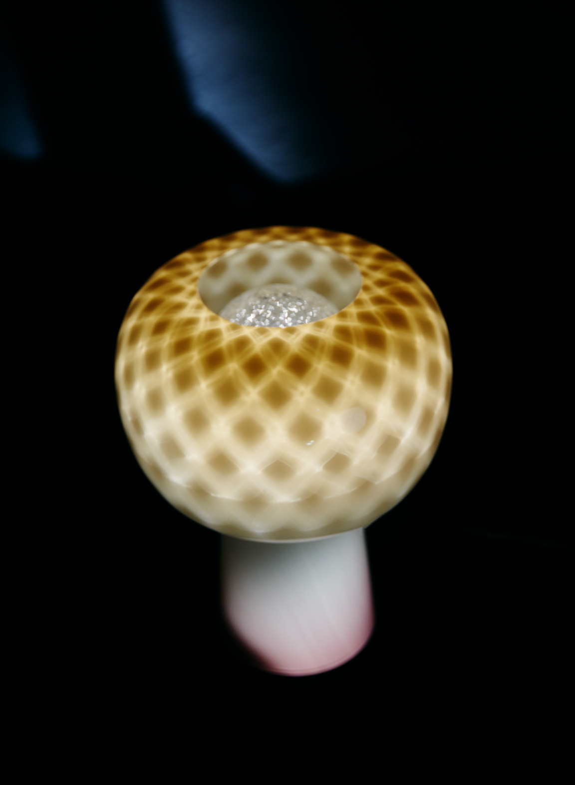 Sustainable design lamp showcasing intricate patterns with a glowing center, representing innovation in materials design.