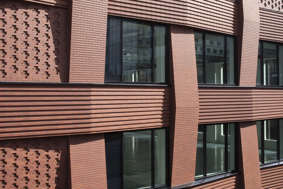 Modern brick facade of BAFTA HQ in London, showcasing intricate textures and large windows, reflecting Benedetti Architects' design.