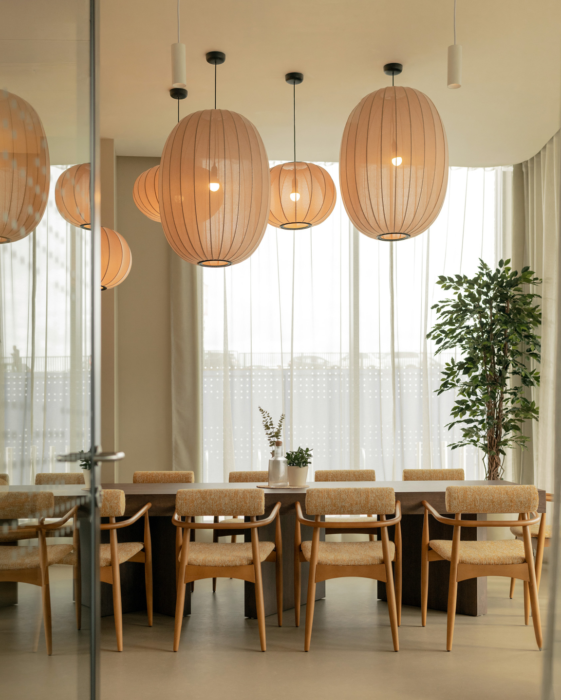 Sophisticated dining area featuring textured lighting, contemporary furniture, and greenery in a PBSA setting in Nottingham.