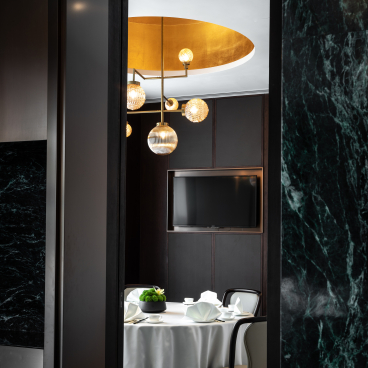 Sleek interior design of the Canton Room featuring a round dining table, elegant lighting, and modern decor in Wan Chai.