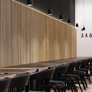 Modern interior of Maru Asian Cuisine featuring wooden paneling, sleek black pendant lights, and minimalist dining tables.