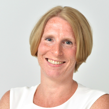 Smiling woman in a white top, representing innovation in luxury vinyl flooring by Karndean Designflooring.