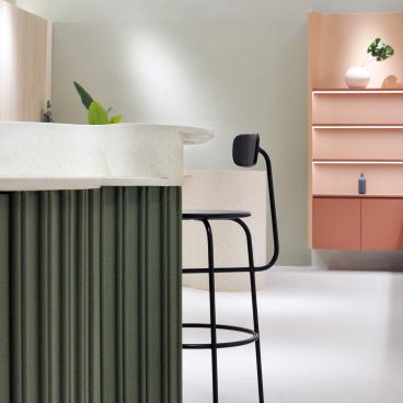 Sculptural interior of an organic skincare flagship store featuring soft curves, textured surfaces, and minimalist design elements.