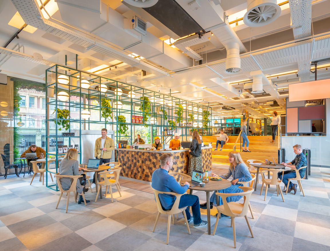 Modern workspace featuring a vibrant café area, where people share skills and collaborate in a dynamic environment.