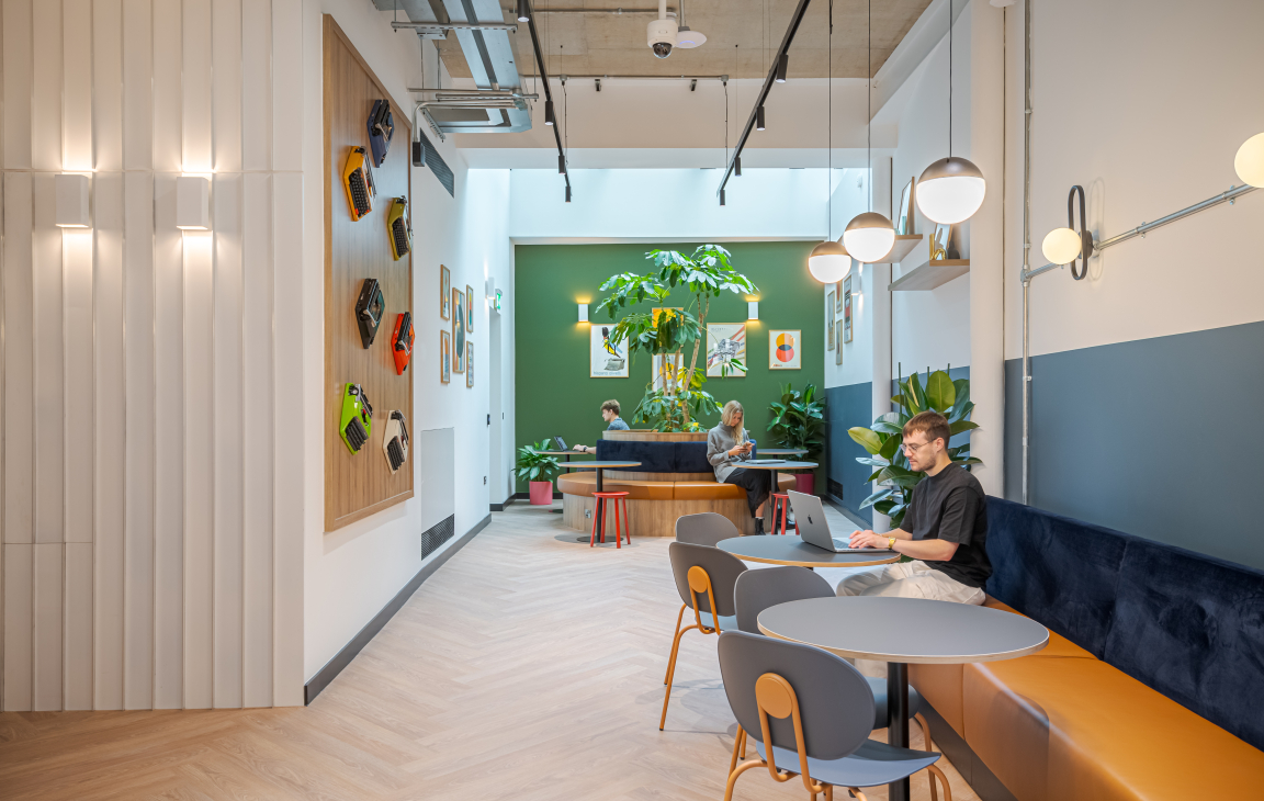 Modern co-working space featuring vibrant decor, greenery, and design elements that evoke creativity and collaboration.