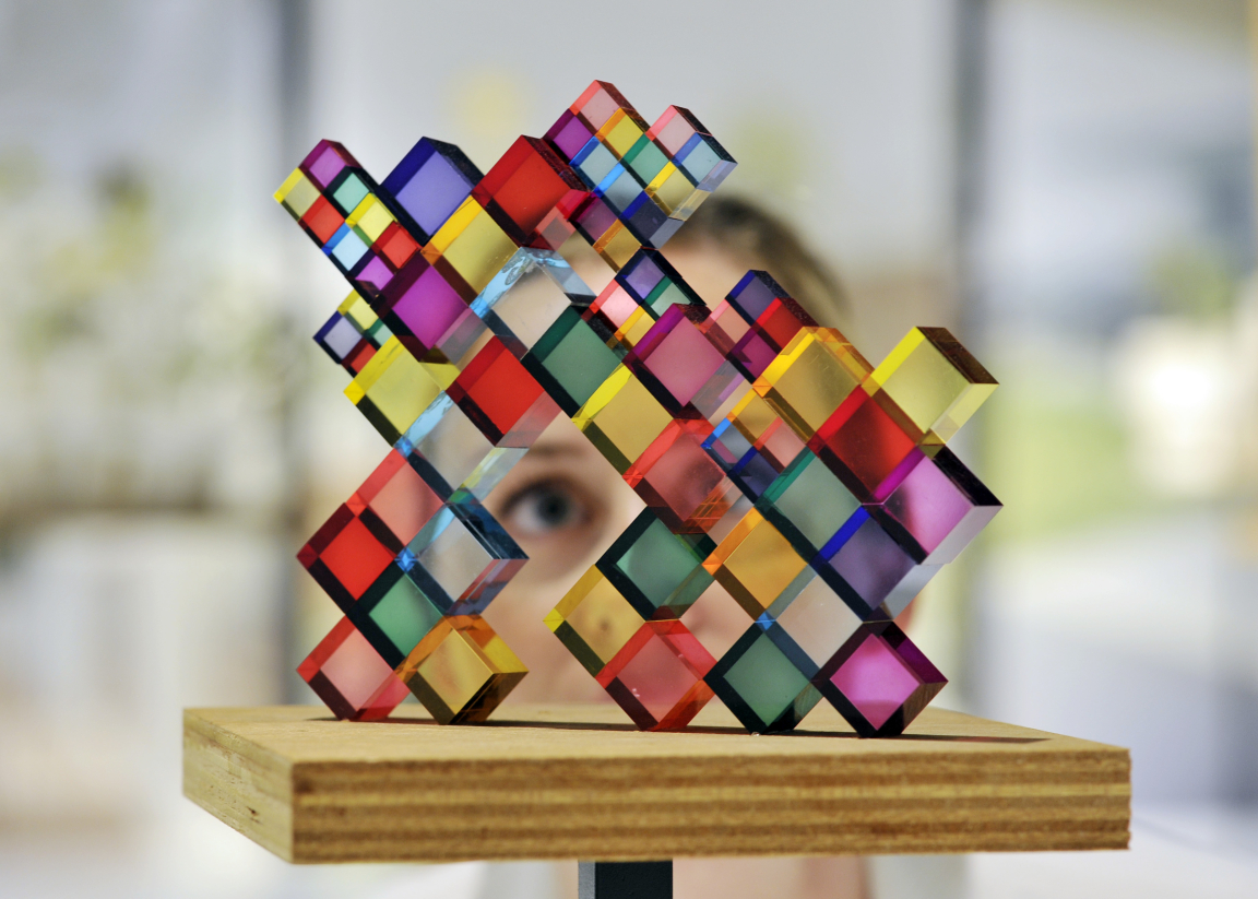 A member of staff at Japan House London inspects Stacked Colours, one of 100 exhibits on display in the inaugural exhibition, Futures of the Future by acclaimed Japanese architect Sou Fujimoto