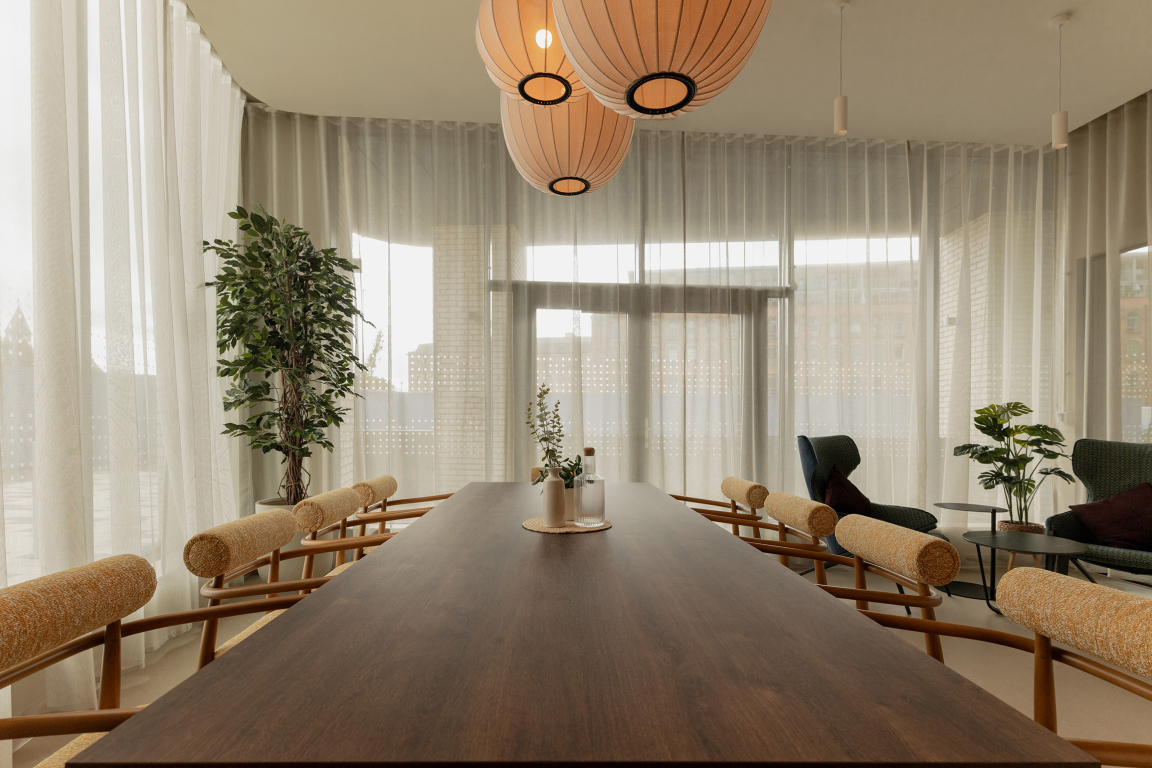 Modern dining area with elegant wood table, stylish chairs, and soft natural lighting in The Place, Nottingham.