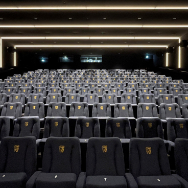 Modern BAFTA screening room with plush seats displaying BAFTA logos, designed by Benedetti Architects for a premium cinematic experience.