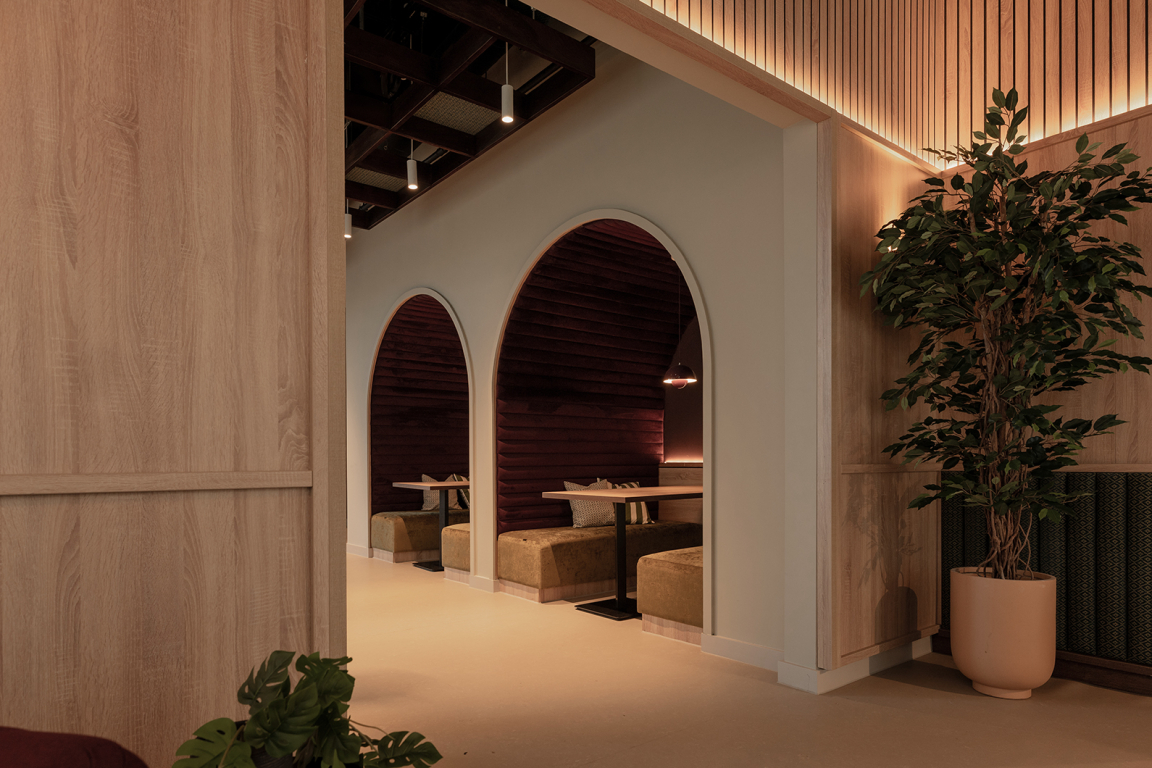 Modern interior showcasing arched booths, warm lighting, and a blend of natural textures at The Place, Nottingham.