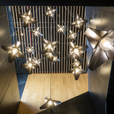 Stylish pendant lights shaped like stars hang from the ceiling, creating a modern atmosphere in the Brew92 coffee shop.