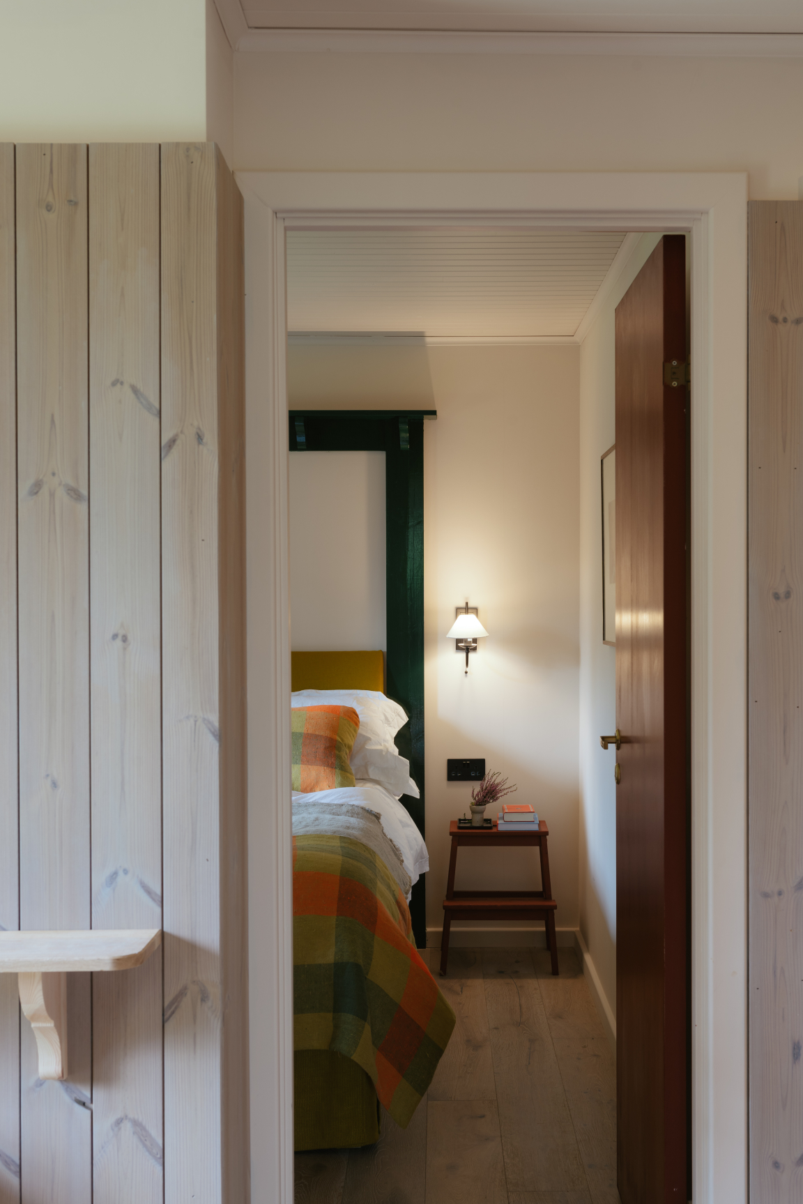 Cozy bedroom retreat featuring Scandinavian design, colorful textiles, and warm lighting in a rustic setting.