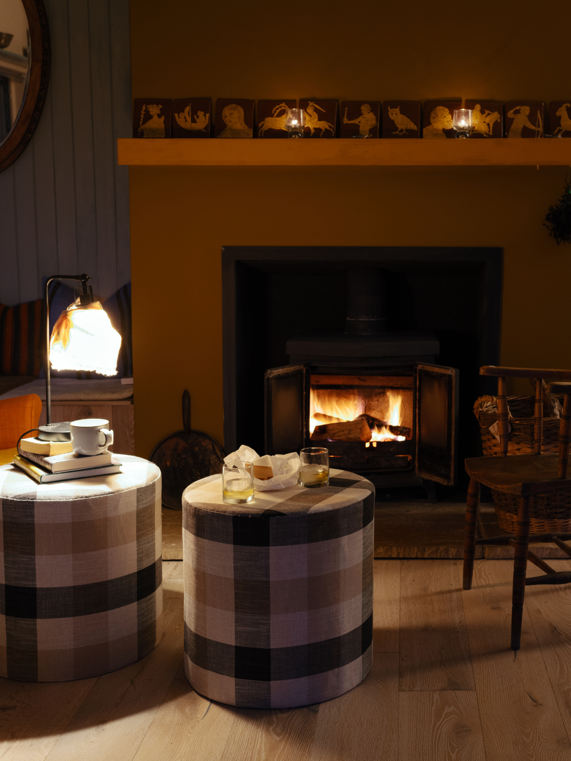 Cozy living space featuring plaid stools, a warm fireplace, and Scandinavian-inspired decor, reflecting Hebridean design influences.