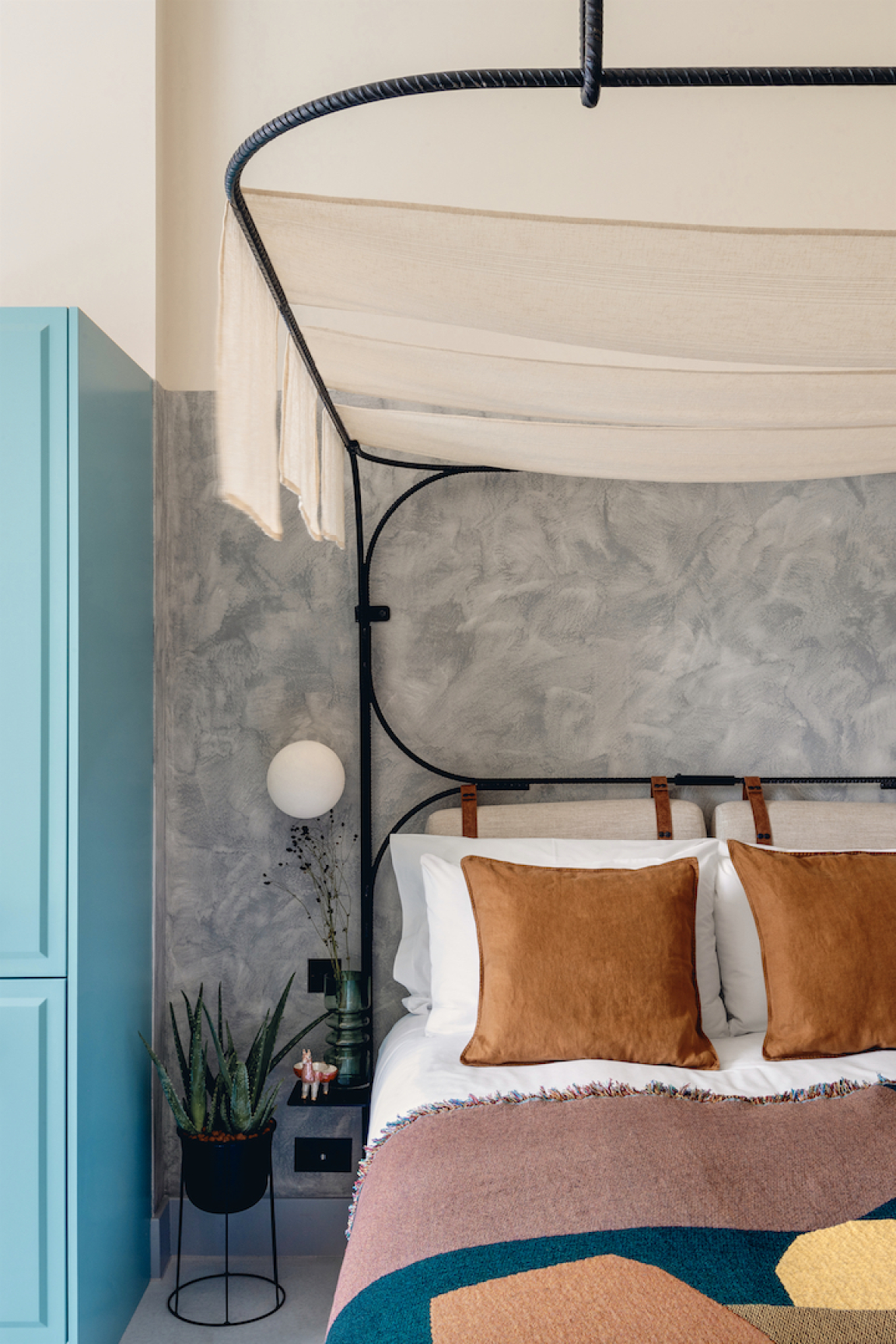 Stylish hotel room featuring a cozy bed, vibrant textiles, and sustainable design elements in Bermondsey.