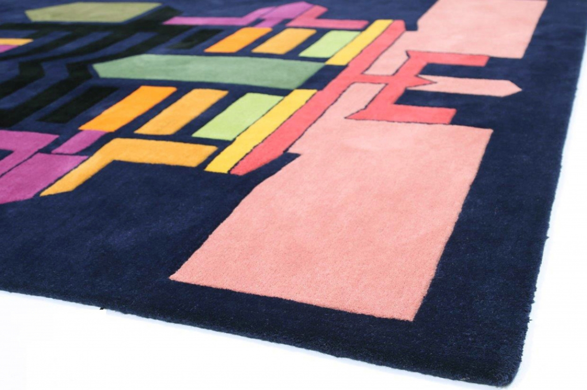 A textured rug featuring vibrant geometric patterns in shades of pink, green, and yellow against a dark blue background.