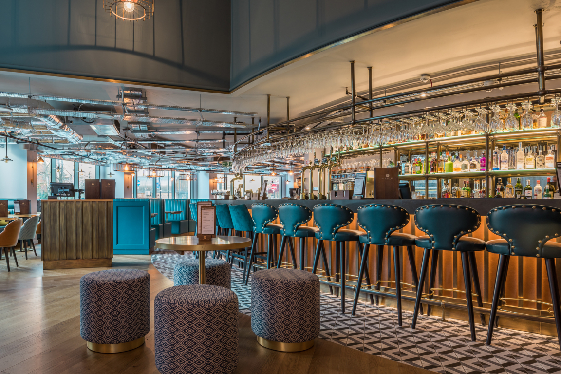 Modern bar interior featuring stylish stools, a vibrant atmosphere, and elegant decor in a Glasgow venue.