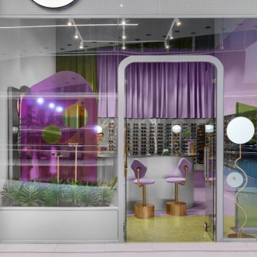 Modern eyewear store Breathe in Colombia featuring vibrant purple decor and stylish display of sunglasses and frames.