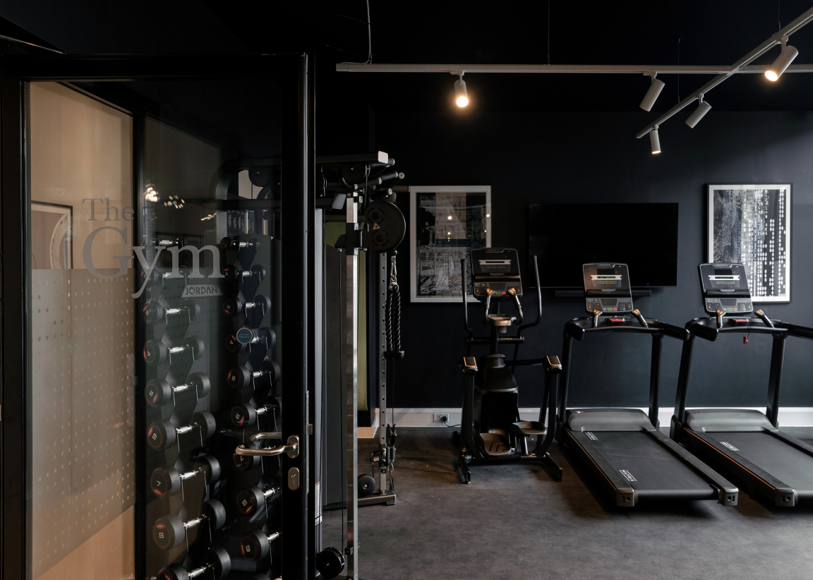 Sophisticated gym interior featuring modern equipment and weights, designed for The Place student accommodation in Nottingham.