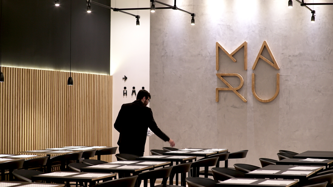 Intimate interior of Maru Asian Cuisine, featuring minimalist design, wooden accents, and elegant table settings in Curitiba.