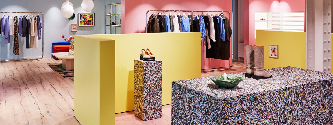 Stylishly designed retail space featuring colorful displays of clothing and accessories in a vibrant studio environment.