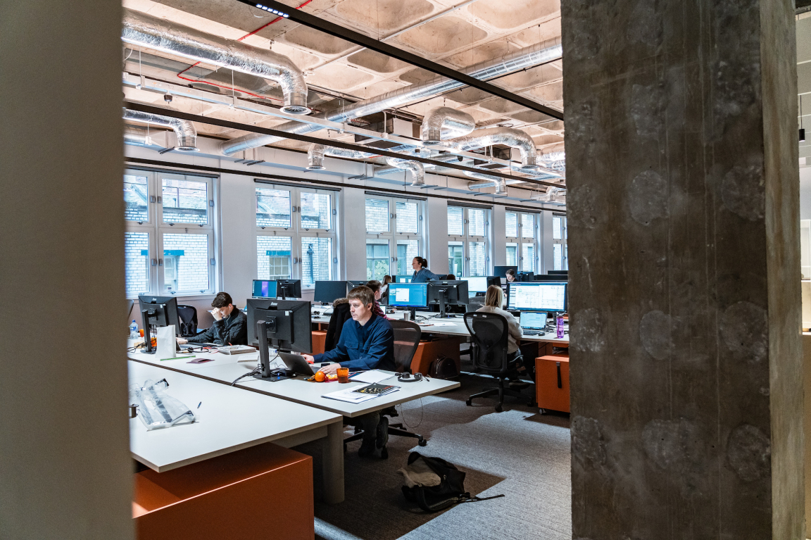 Modern office environment at BDP Glasgow, showcasing employees engaged in collaborative design work at their desks.