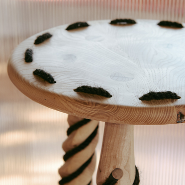 Wooden stool featuring human hair accents, highlighting innovative use of hair as a sustainable material in design.