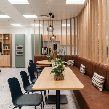 Modern breakout area with calming decor, featuring wooden accents, comfortable seating, and vibrant plants at Calibro Workspace.