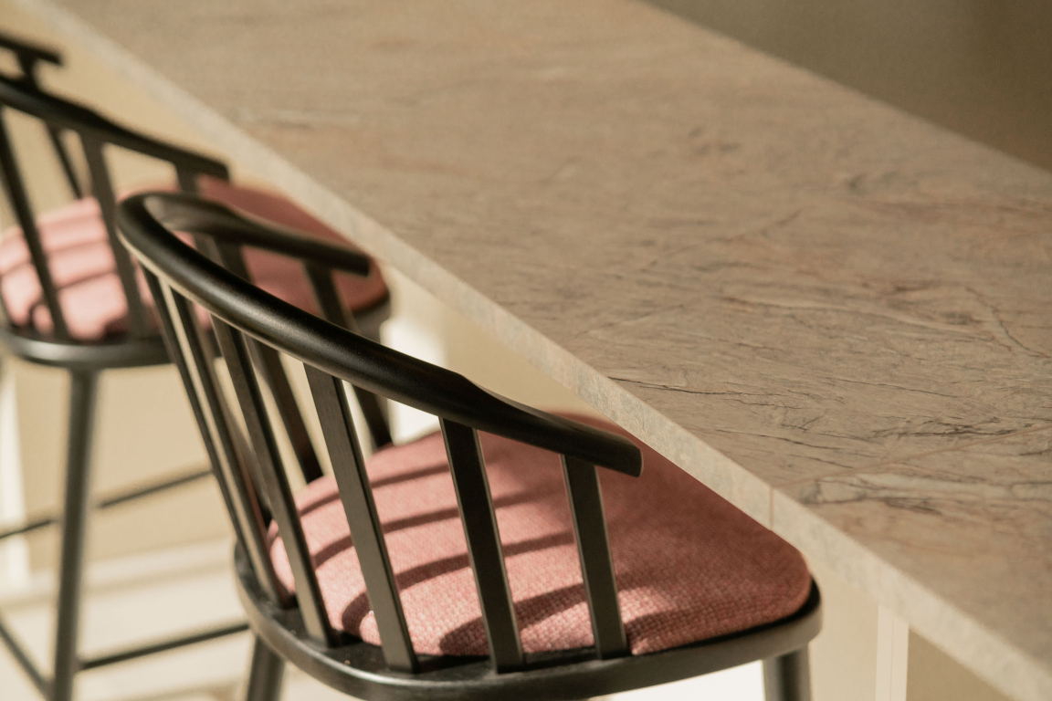 Stylish bar stools with pink cushions beside a textured countertop in a modern interior design at The Place, Nottingham.