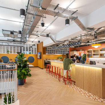 Vibrant co-working space inside The Typewriter building, featuring a modern kitchenette and collaborative work areas.