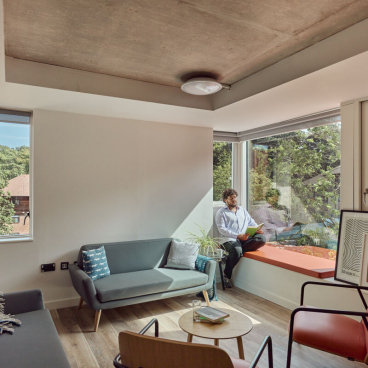 Modern student accommodation interior at Oxford Brookes University featuring a cozy seating area and large windows.