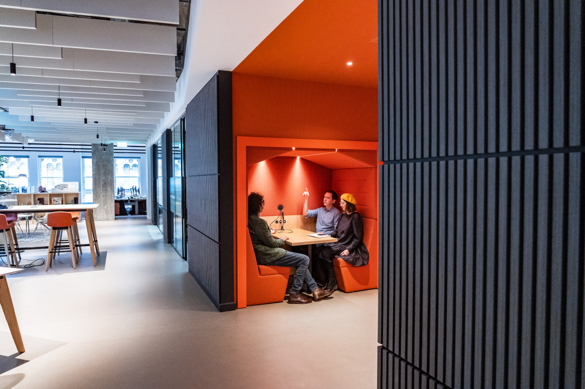 Modern office pod featuring collaborative workspace with three individuals engaged in discussion at BDP Glasgow's new Grosvenor Building location.