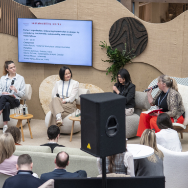 Panel discussion at Workspace Design Show 2025 focusing on sustainable design, featuring industry experts in a vibrant setting.